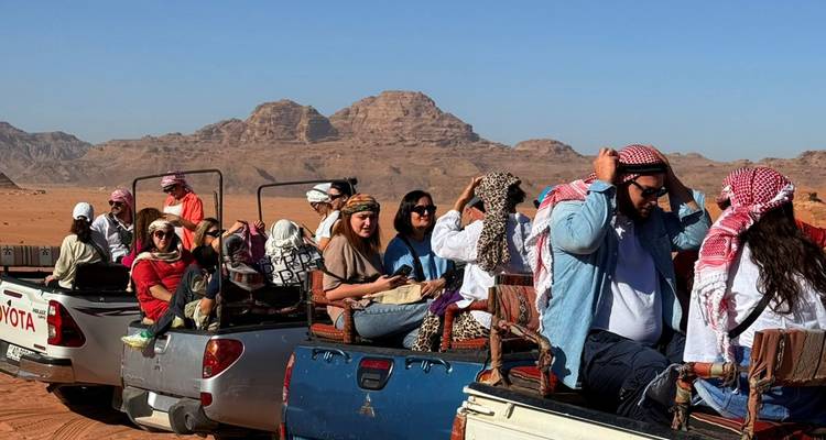 Des gens dans des véhicules de safari visitant le désert.