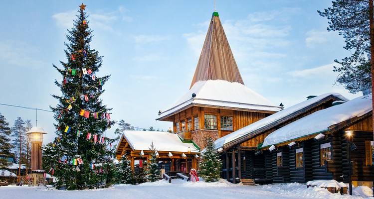 Santa Claus Village with decorated Christmas tree in the snow.