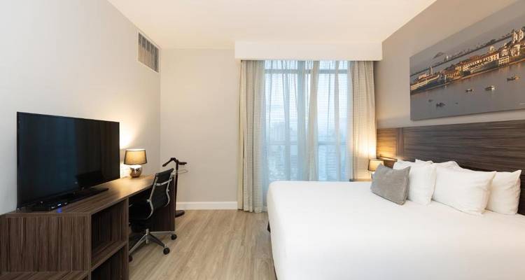 Habitación de hotel minimalista con mobiliario moderno y vistas a la ciudad.