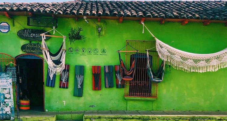 Bâtiment en adobe d'un vert citron éclatant orné de hamacs et d'objets d'artisanat dans une petite ville