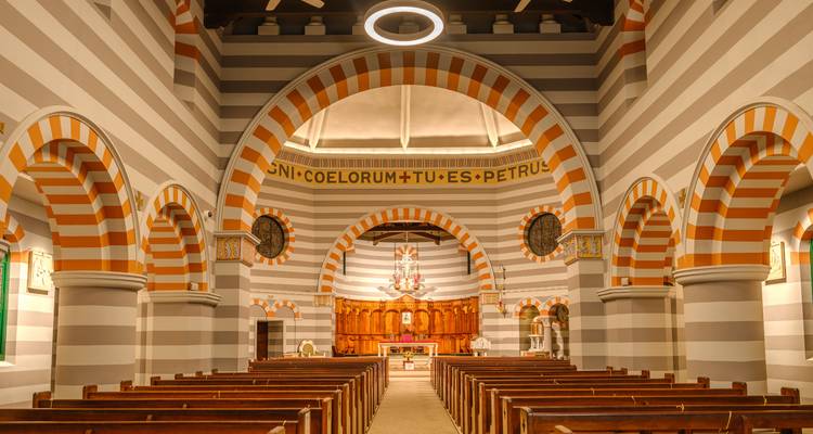 Innenraum einer Kirche mit gestreiften Bögen.