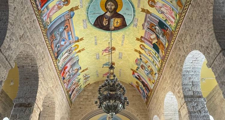 Sierlijke kerkzoldering met religieuze schilderingen.