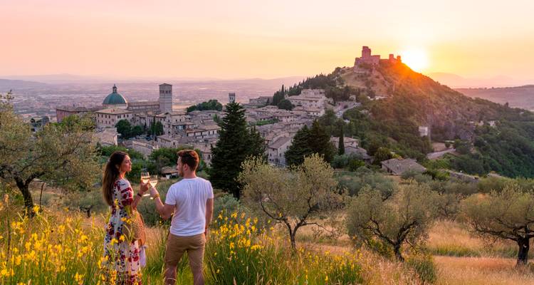 Couple enjoying a sunset over a historic town.