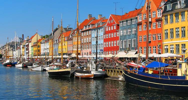 Les maisons colorées emblématiques et les hauts mâts qui bordent le canal de Nyhavn à Copenhague lors d'une journée ensoleillée.