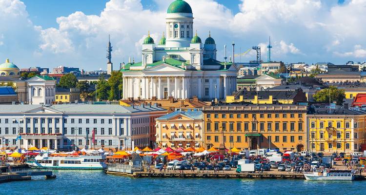 Helsinkis weiße, kuppelförmige Kathedrale, die sich über farbenfrohen Marktständen entlang der Uferpromenade erhebt.