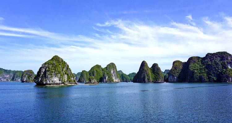 Karstformationen im Meer unter einem strahlend blauen Himmel.