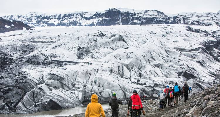 Senderismo grupal en un glaciar con formaciones rocosas.