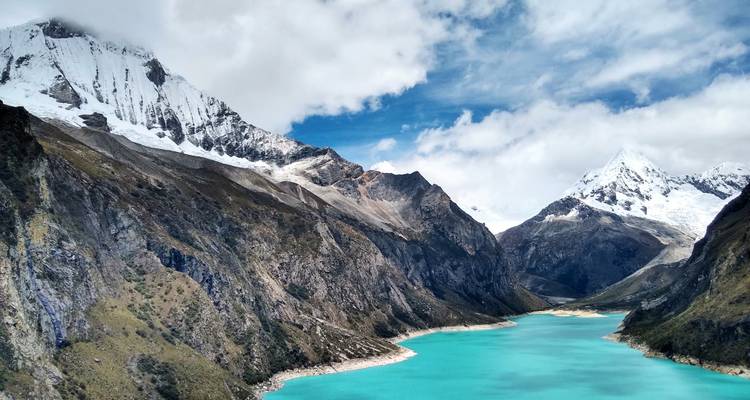 Betoverende aanblik van een gletsjermeer omringd door hoge besneeuwde bergen.