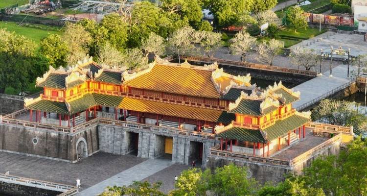 Aerial view of the ornate entrance gate of the Imperial City of Hue surrounded by lush greenery and moats.