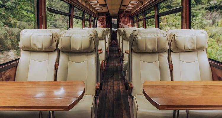 Interieur van een luxueuze trein met leren stoelen en tafels.