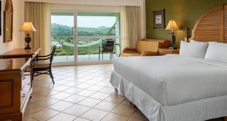 Chambre d'hôtel avec un grand lit et une vue sur l'extérieur.
