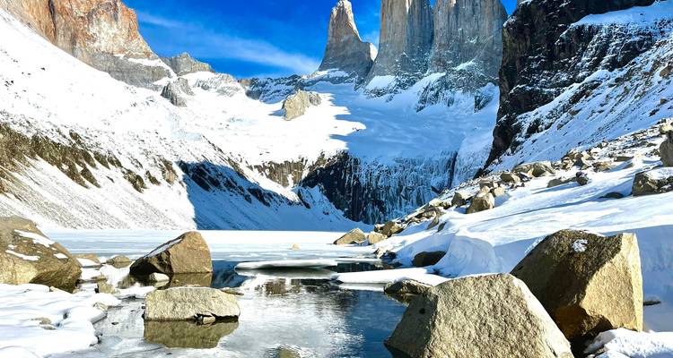 Sneeuwbedekte toppen met een gedeeltelijk bevroren meer
