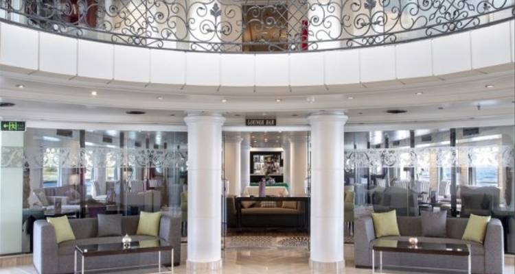 Elegant interior of a lounge with bright natural lighting and seating areas.