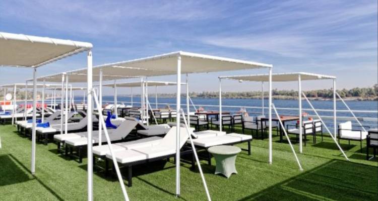 Sun loungers and parasols on a cruise ship overlooking a river.