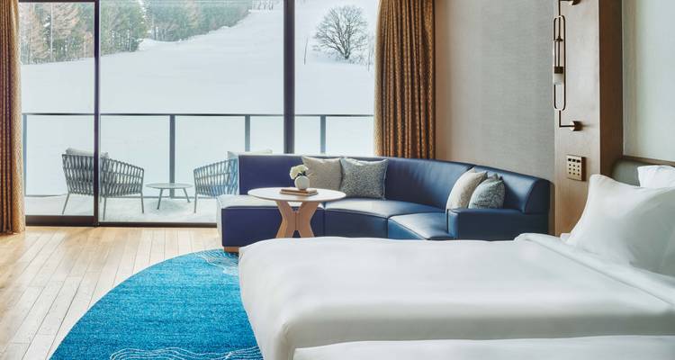 Chambre d'hôtel luxueuse avec vue sur un paysage enneigé.