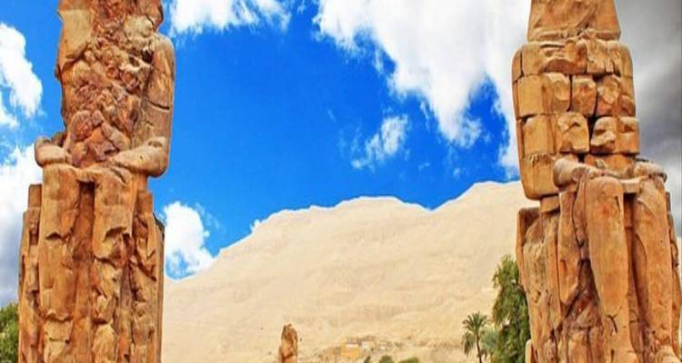 Kolossi van Memnon beelden in een woestijnlandschap.