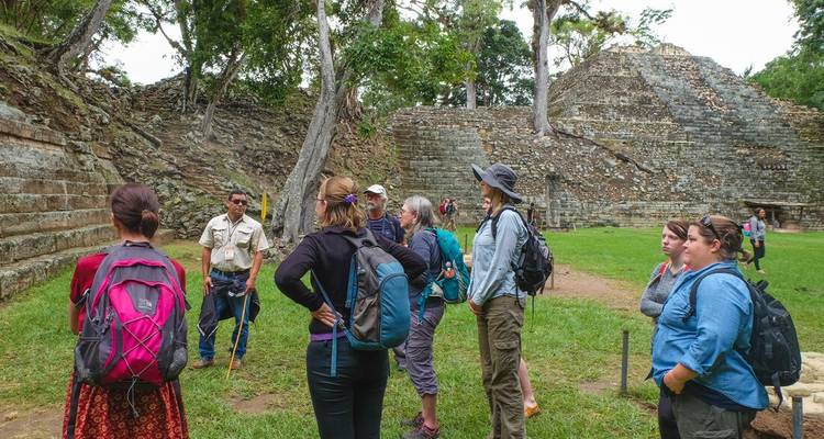 Un groupe recevant une visite guidée dans des ruines antiques.