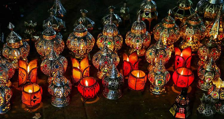 Colección de lámparas marroquíes ornamentadas de metal y vidrio brillando con la cálida luz de las velas.