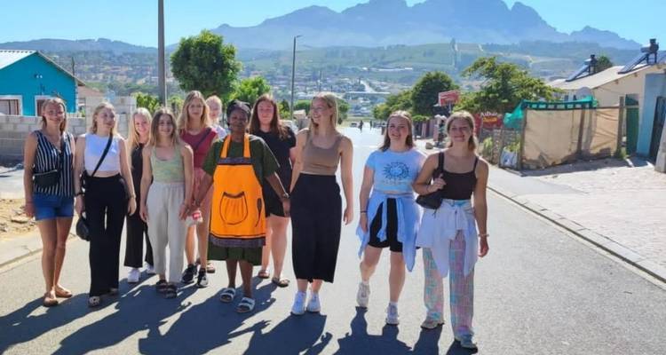 Grupo de personas caminando por una calle en un pueblo.