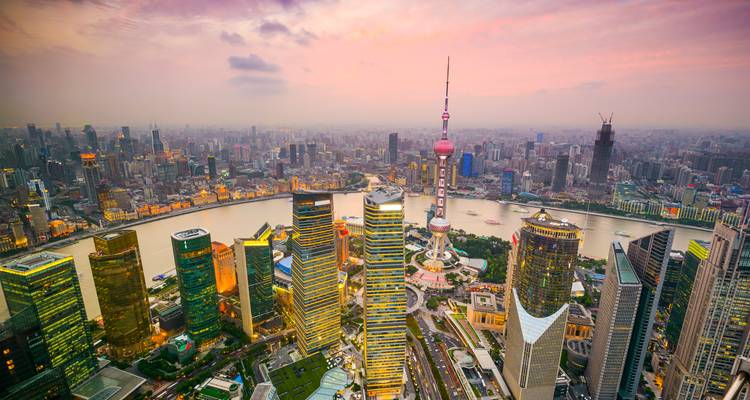 Skyline of a modern city at dusk with colorful lighting.