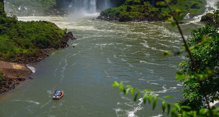 River leading to Iguazu Falls with a small boat.
