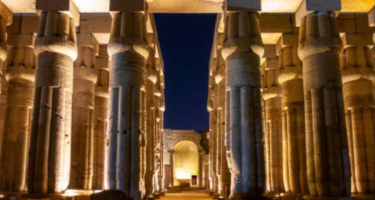 Antike Säulen, die nachts beleuchtet sind und eine dramatische Wirkung erzeugen.