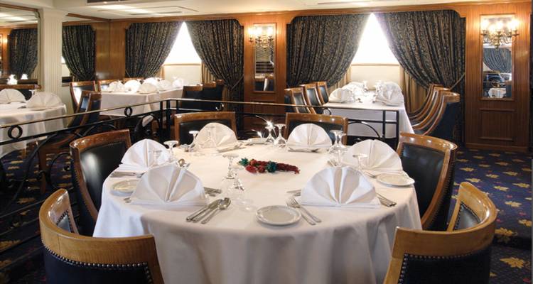 Eleganter Essbereich mit rundem Tisch und gedecktem Besteck.