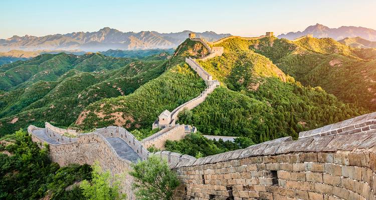 Gran Muralla China extendiéndose a través de un paisaje montañoso.