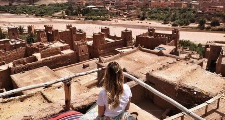 Personne regardant les anciennes structures en argile d'Aït Benhaddou.