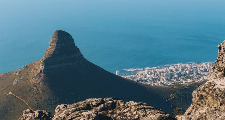 El icónico pico de la Cabeza del León se eleva sobre la ciudad de Ciudad del Cabo y el Océano Atlántico visto desde la Montaña de la Mesa.