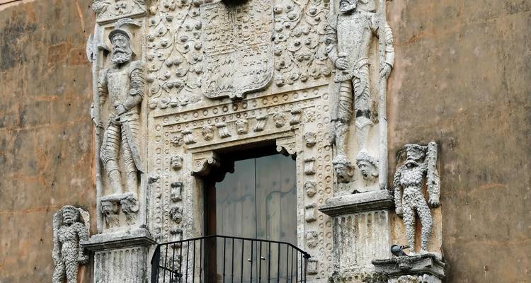Primer plano de una fachada de piedra antigua ornamentalmente decorada.