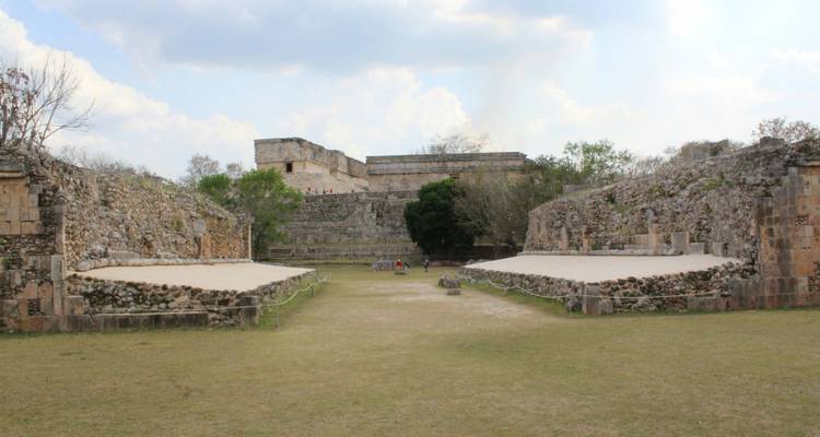 Ruinas antiguas con un cielo despejado y colinas al fondo.