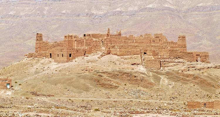 Ruïnes van een oud fort op een zandige heuvel.