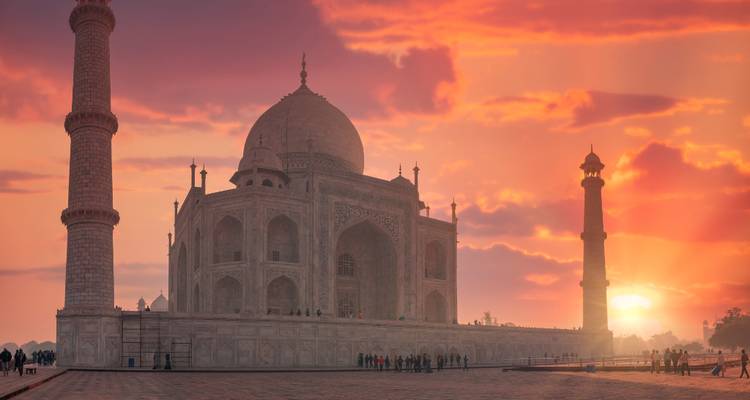 Taj Mahal bij zonsopgang met een oranje lucht.