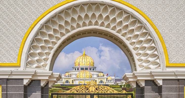 Palacio real con cúpula enmarcado perfectamente a través de un arco ornamentado en Istana Negara, Kuala Lumpur