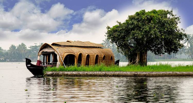 Hausboot auf einem ruhigen See mit üppigem Grün.