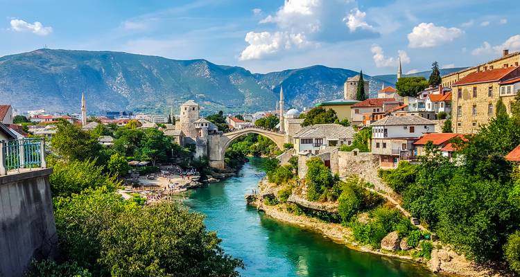 Mostar with famous bridge over turquoise river and mountains.