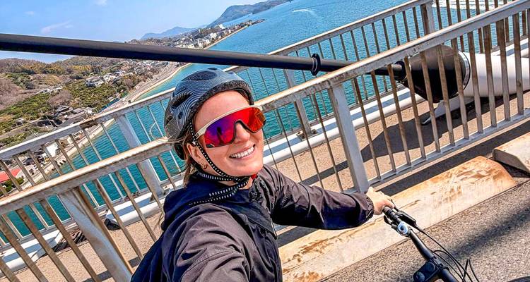 Een fietser maakt een vrolijk selfie op een brug met uitzicht op de blauwe Seto Binnenzee.