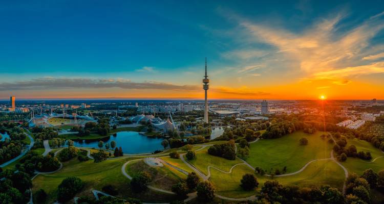 Panoramisch uitzicht op München met de Olympiatoren bij zonsondergang.