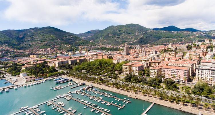 Vista aérea del puerto deportivo de La Spezia lleno de barcos, enmarcado por colinas verdes