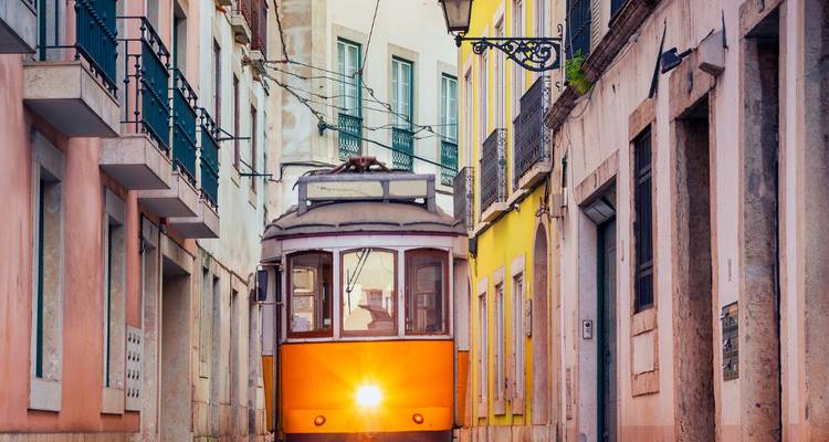 A classic yellow tram in a narrow street in Lisbon.