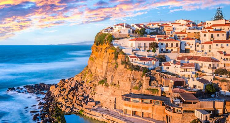 A picturesque village by the sea with stunning cliff views at sunset.