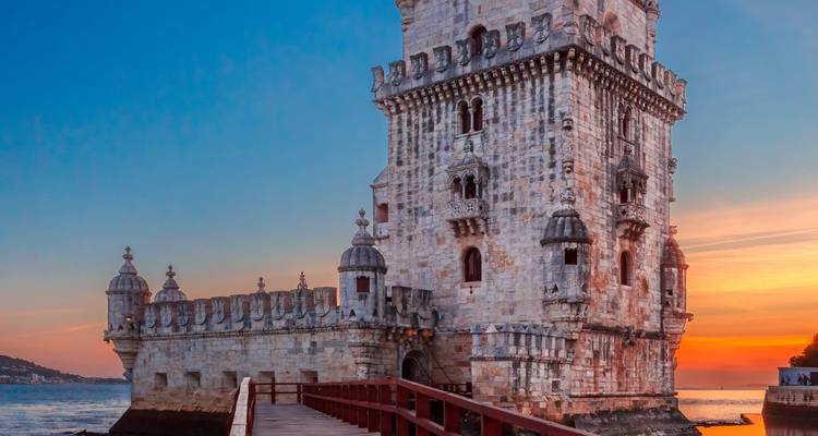 Tower of Belém at sunset with a vivid sky backdrop.