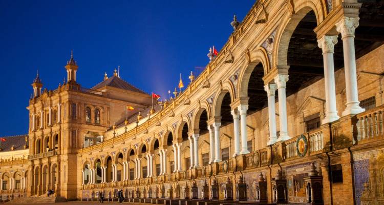 Plaza de España in Sevilla bei Nacht beleuchtet mit ihrer historischen Architektur.