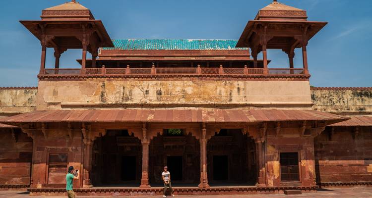 Un bâtiment historique avec une personne devant, prenant une photo.