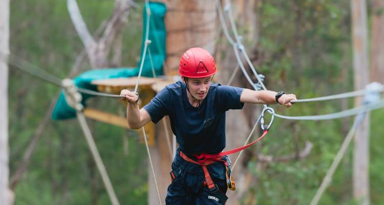 Person engaged in a high ropes course activity.