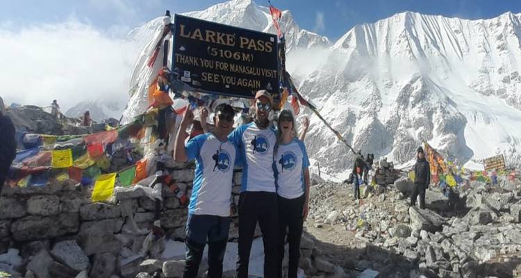 Group of people with a sign at a mountain pass