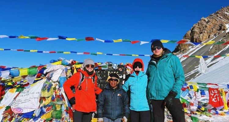 Group of people in bright winter gear at a snowy pass