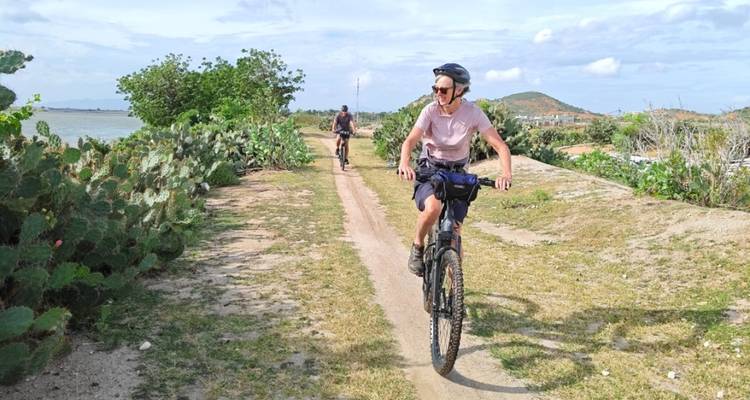 Cyclistes sur un sentier de terre entourés par la nature.