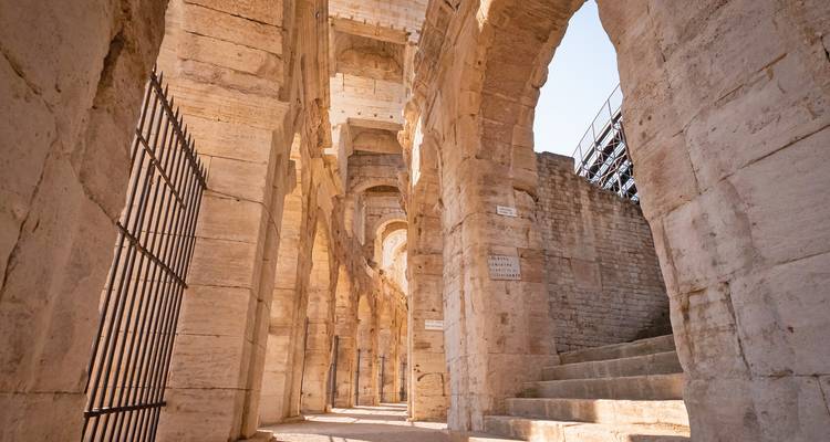 Couloirs et arches de pierre ensoleillés à l'intérieur d'un ancien amphithéâtre romain.